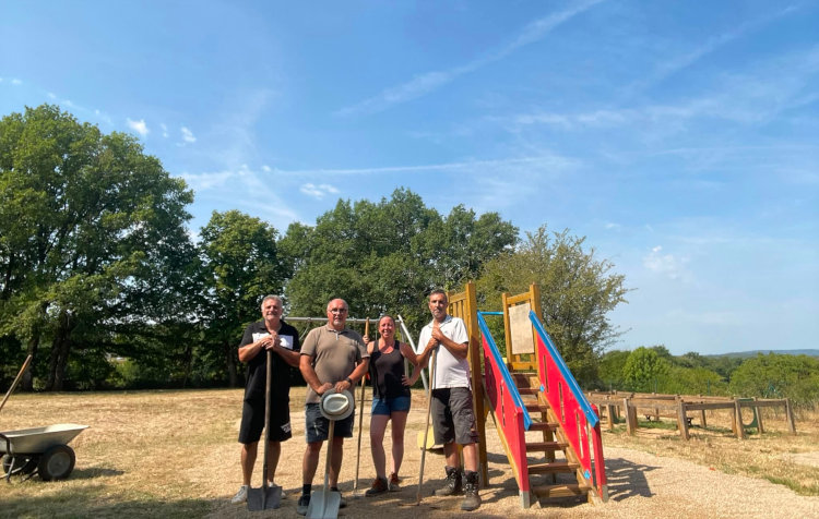 Photo des employés communaux et des élus devant les jeux extérieurs de l’école