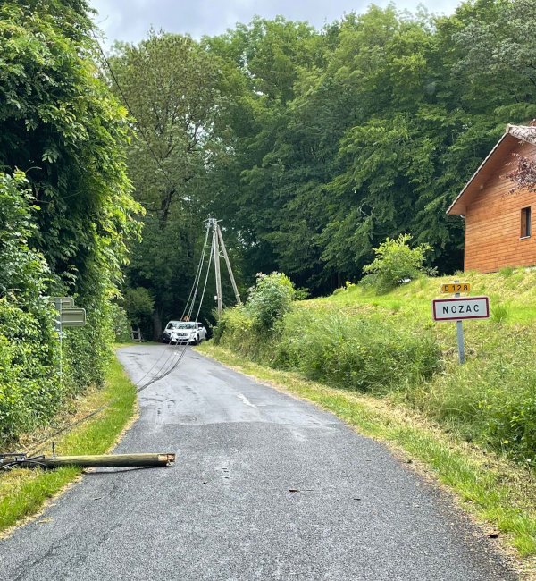 Photo du poteau téléphonique endommagé sur la route